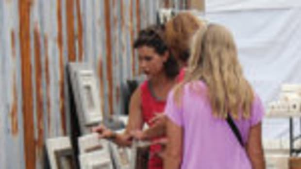 A group of customers looks through pieces in an outdoor booth at Scott Antique Markets in Atlanta.