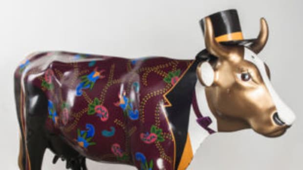 Life-size ceramic cow in a top hat