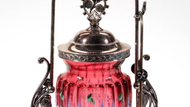 Victorian lobed and enamel-decorated pickle castor, cranberry with polychrome-enamel decoration, 21-lobe form, fitted into a quadruple-plated stand marked for “WM. ROGERS MFG. CO.” and numbered “449,”with tongs and cover. Maker unverified, fourth quarter 19th/20th century, stand 10-5/8” h, insert 4-5/8” h; $275.