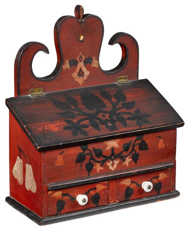 A Pennsylvania painted poplar hanging wall box, mid 19th c., retaining its original decoration with flowers and fruit on a red ground; estimate: $10,000-$15,000.