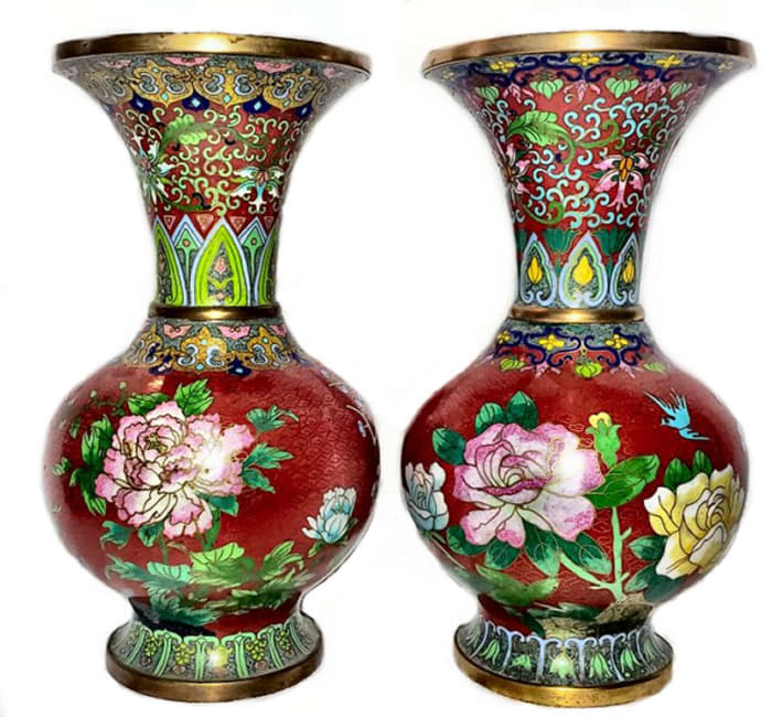 The enameling in cloisonné is overall, whereas the enameling in champlevé is done in well delineated areas. In this pair of large cloisonné vases, the base metal is clearly visible at the base and rims.
