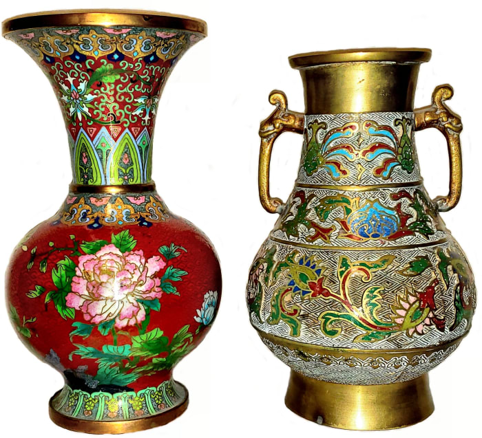Champlevé and cloisonné objects of roughly the same size will differ considerably by weight, with the champlevé weighing more due to the thick metal base required for carving. The base metal in champlevé (shorter vase on the right) is apparent overall, while the base metal in cloisonné (taller vase on the left) is usually visible at the base, rim and interior; the small partitions in cloisonné are clearly visible on close examination. This image compares a ten-inch cloisonné vase with a nine-inch champlevé vase. Although the champlevé vase is shorter by an inch, it weighs a pound more due to the thickness of the base metal.