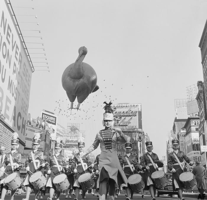A helium-filled Turkey on it’s way through Times Square in 1959, accompanied by a marching band.