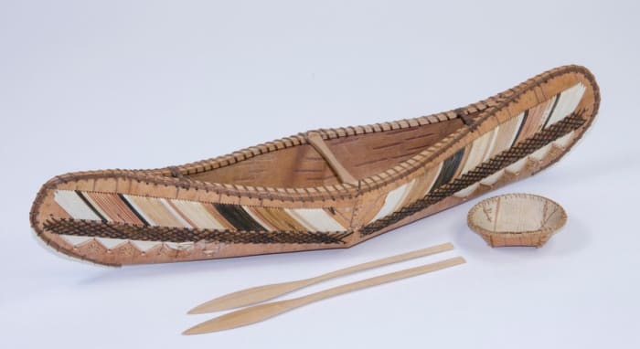 Birch-bark model canoe, 1869, sewn with spruce root and the exterior decorated with porcupine quills; contains a miniature birch-bark circular bowl and two wooden paddles. This was presented to Prince Arthur Duke of Connaught in Canada in 1869.