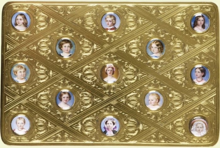 This gold and enamel box, 1” x 5” x 3.3”, features miniature portraits of Queen Victoria and Prince Albert Edward and their children Princess Alice, Prince Alfred, Princess Helena, Princess Louise, Princess Helena, Princess Louise, Prince Arthur, Princess Beatrice, and Victoria, Princess Royal. The enamel studs were given as gifts by Queen Victoria to Prince Albert in commemoration of their wedding anniversary in February 1859 and also on her birthday in May 1859.
