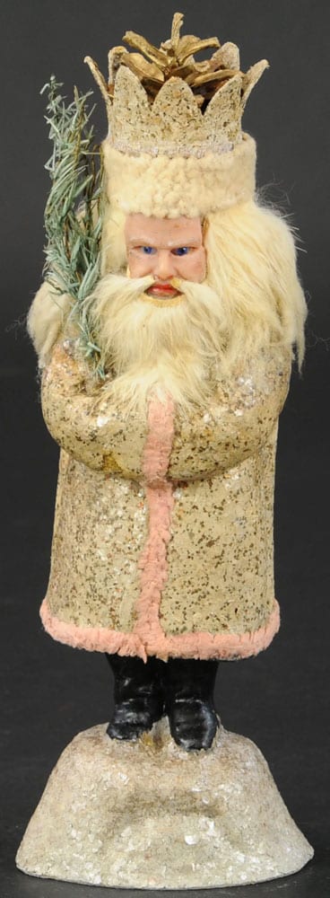 A rare and stern-looking Belsnickle with deep-set blue glass eyes and head of long mohair, and wearing a mica-flecked robe with pink trim and a distinctive pine-cone crown; 11" h. This sold in 2020 for $4,250.