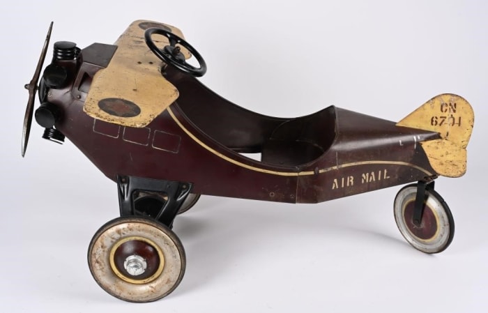 A 1920s Steelcraft "Little Jim" Air Mail pedal airplane, 100 percent original, as-found condition with maroon and cream paint, and original Little Jim decal on back of seat. Sold for $10,500 against an estimate of $3,000-$5,000.