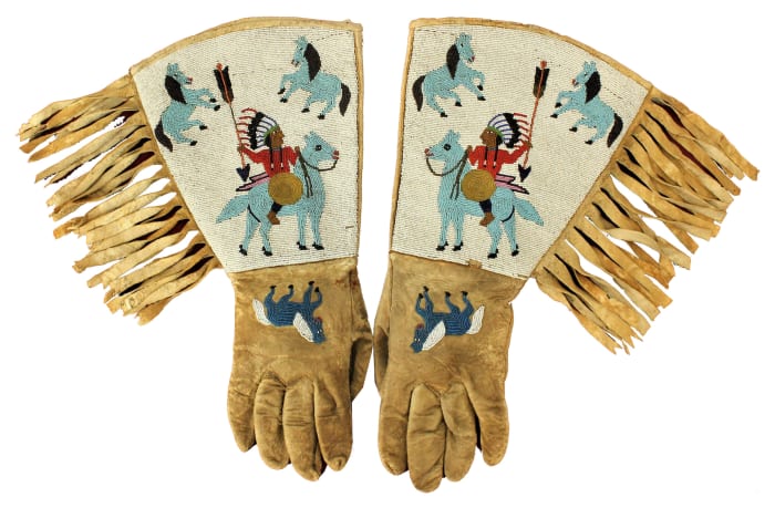 Turn-of-the-century Native American (Plateau)  gauntlets, fully beaded  with images of multiple  figures, including Indian  chiefs and horse. Estimate: $4,500-$7,500.