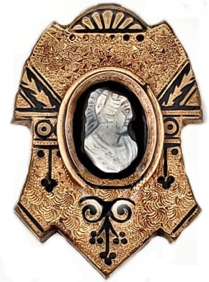 This appearance of this textured gold brooch with a hardstone cameo is greatly enhanced by the black enamel tracery seen in many mid-Victorian pieces of jewelry.