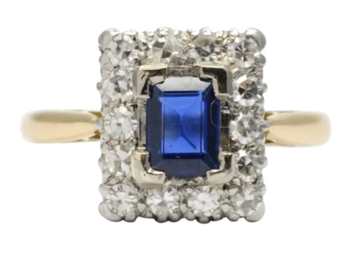 Rectangular sapphire and diamond cluster engagement ring set in 18k gold and platinum, 1920. The deep royal blue sapphire weighs 0.50 carat and is surrounded by 8-cut diamonds totaling 0.42 carat; $1,100.