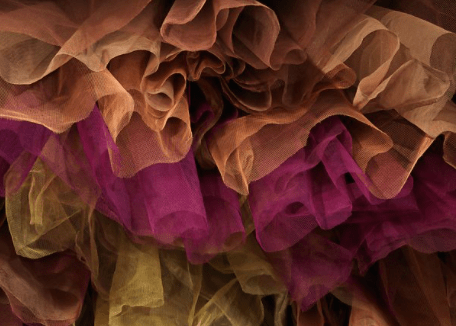 The yellow, purple, light brown, and brown nylon tulle layered underneath the gown.