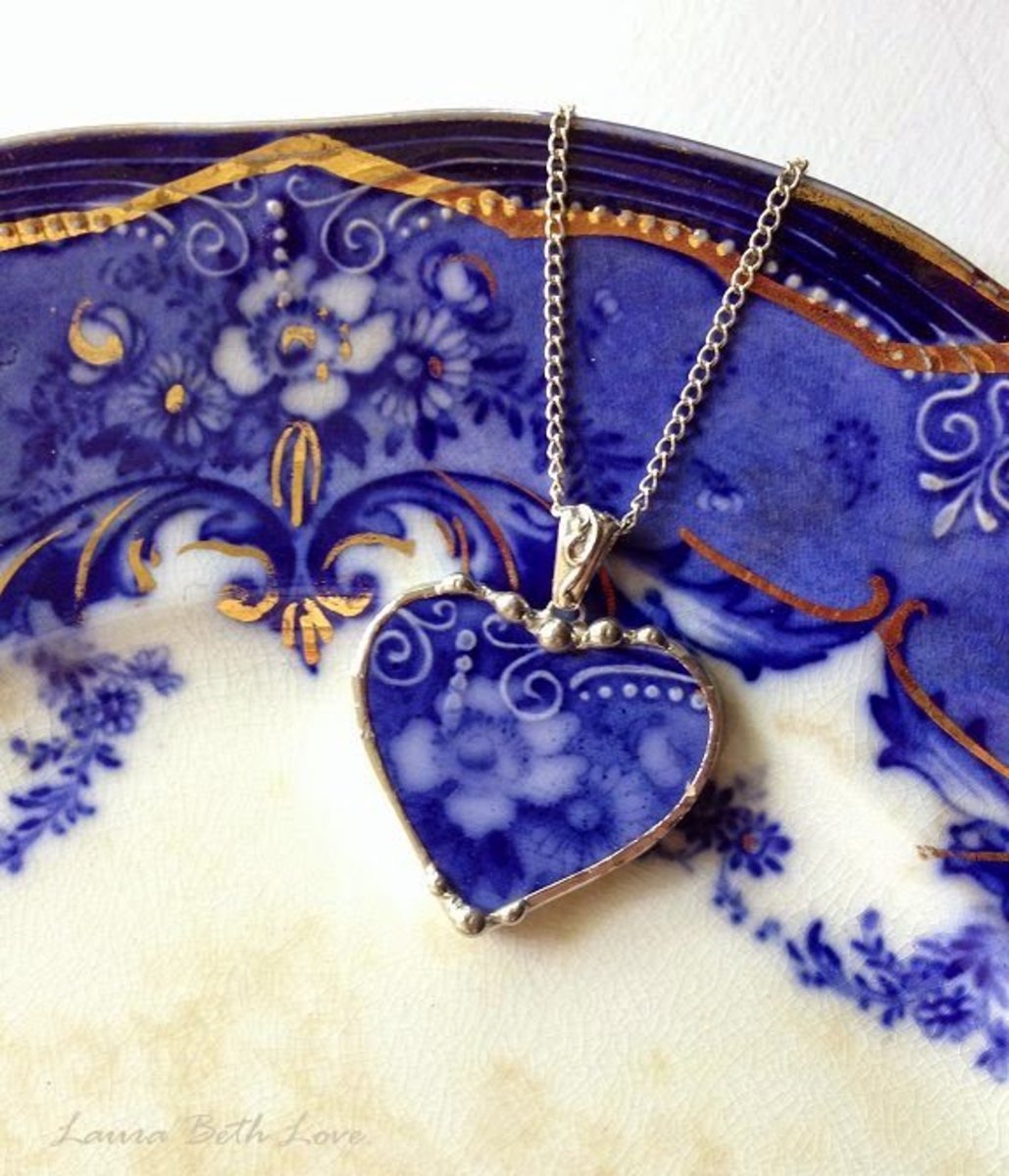 A heart-shaped pendant from a piece of flow blue pottery.