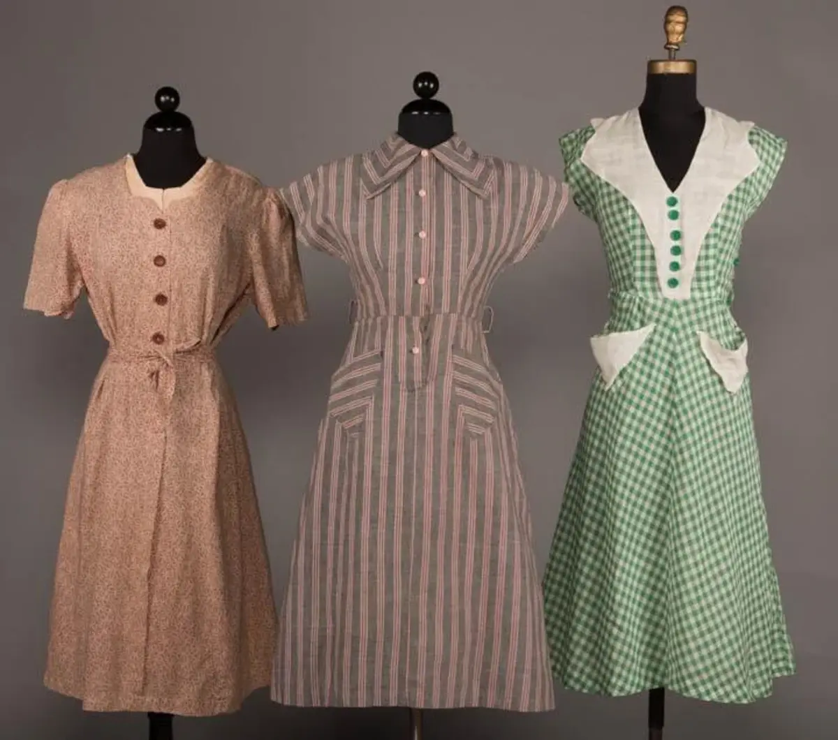 Lot of three cotton house dresses, 1940s-50s: one tan with a ribbon and bow motif, one gray and pink striped with a chevron collar, and a green and white gingham; $150.