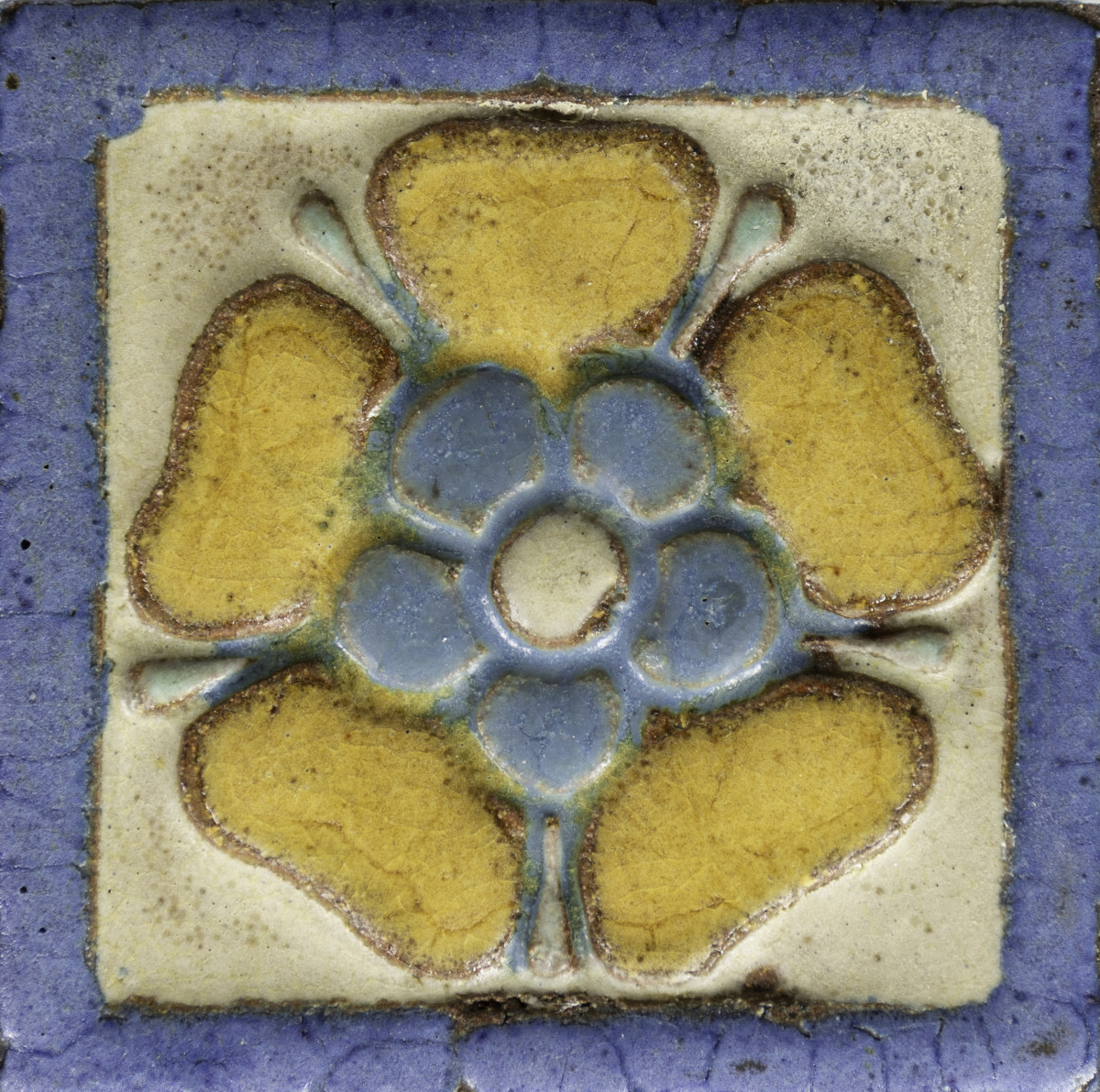 A Grueby art pottery tile of a Tudor rose.