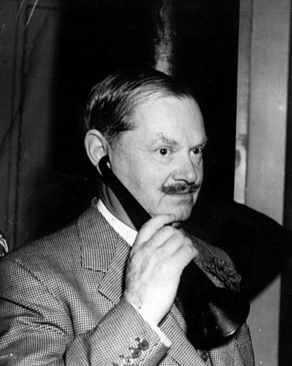 Evelyn Waugh with a tortoiseshell ear trumpet given to him by the Dowager Duchess of Devonshire.