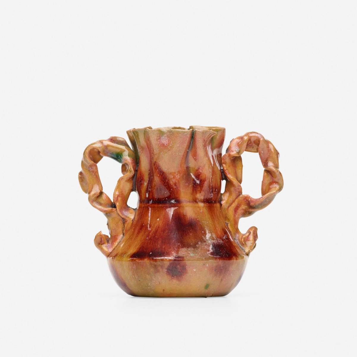 Rare miniature vase, 1895-96, with crimped ear handles and a raspberry, ochre, andgreen glaze, 3” h × 3-1/2” w × 2-1/2” d; sold for $8,500 at Rago.
