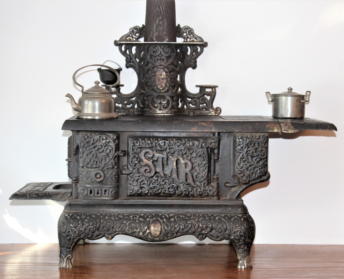 A miniature child’s toy stove, 14 inches long and 10 inches tall, from the late 1800s.