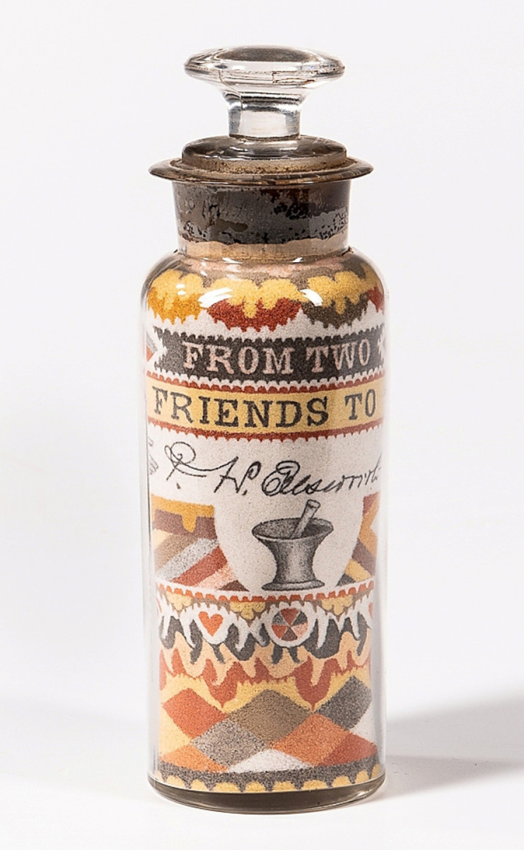 Andrew Clemens' "From Two Friends"sand art bottle, c. 1885-90, which had set a record at Skinner in 2020, after selling for $275,000. The patriotic-themed bottle, dedication to Dr. Prosper Harvey Ellsworth, features an eagle, flag, mortar and pestle, and geometric and abstract designs.