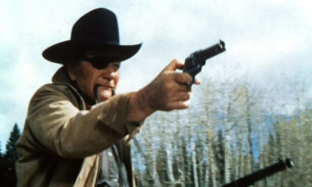 John Wayne, as character Rooster Cogburn, using the revolver in the 1969 movie, True Grit.