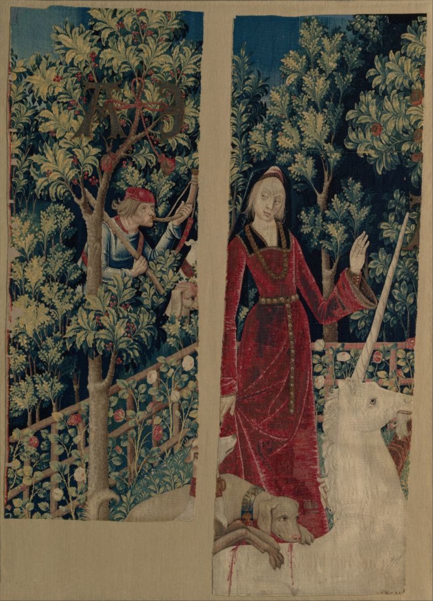 Tapestry 5: The Mystic Capture of the Unicorn. In these two fragments of a single tapestry, the unicorn appears to have been tamed. He stares loving at the maiden who must have subdued him and seems oblivious to the dog licking the wound on his back. However, the presence of one of the hunters blowing his horn does not bode well. Most of the maiden’s figure is missing due to the damage incurred after the tapestries were looted in 1793.