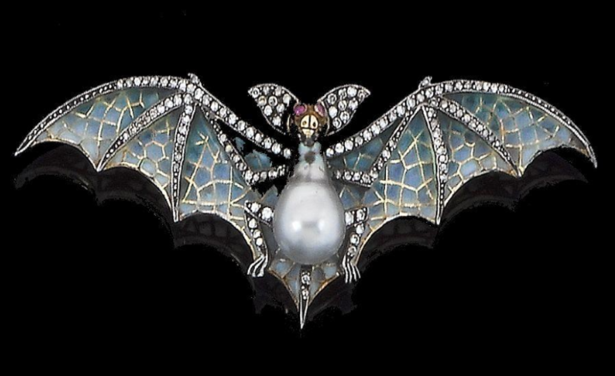 A cultured pearl, diamond, ruby and enamel bat brooch, the body set with a pear-shaped pearl of gray tint, the outstretched wings decorated with pliqué-à jour-enamel, with single-cut diamond detail and ruby eyes; sold at Bonhams for $2,143.