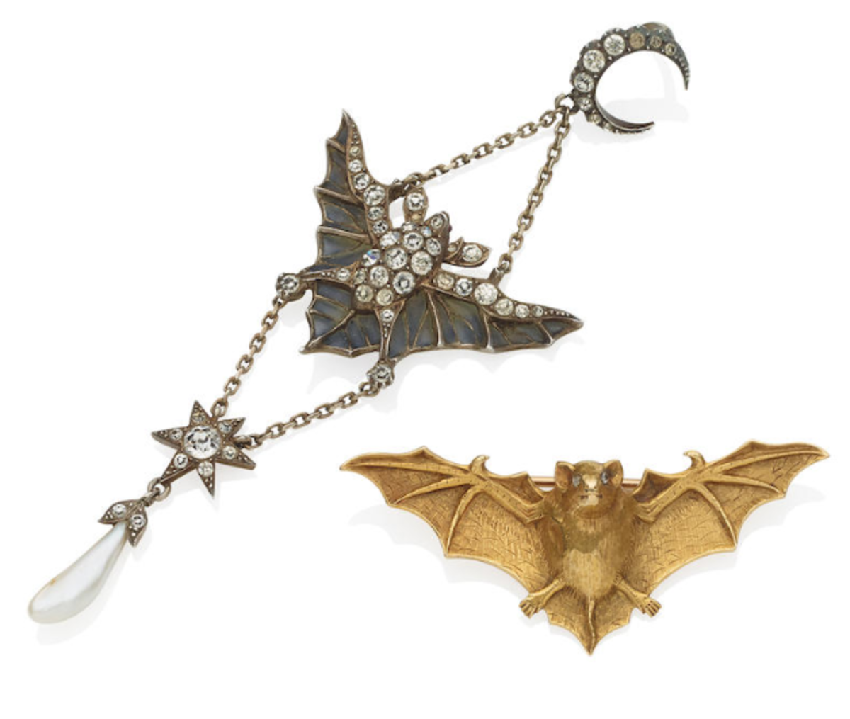An Art Nouveau gold and diamond-set bat brooch and pendant, circa 1900. The brooch is sculpted as a textured gold bat with out-stretched wings and rose-cut diamond eyes and the pendant is designed as a bat with green plique-à-jour out-stretched wings, decorated throughout with circular paste, suspending a similarly-set star and freshwater pearl drop, to the paste-set crescent moon surmount. Sold at Bonhams for $3,671.