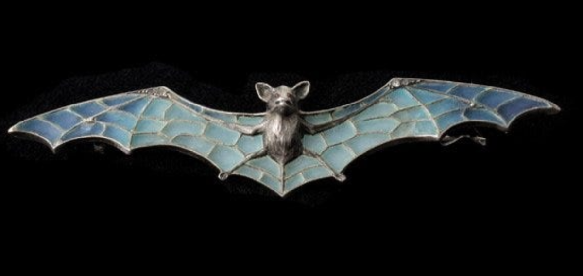 A silver bat brooch featuring plique-à-jour enamel wings accented with four white sapphires and the bat's eyes feature two round cabochon-cut red stones, 4-1/2” l x 1” h. This sold at Michaan’s Auctions for $3,750.