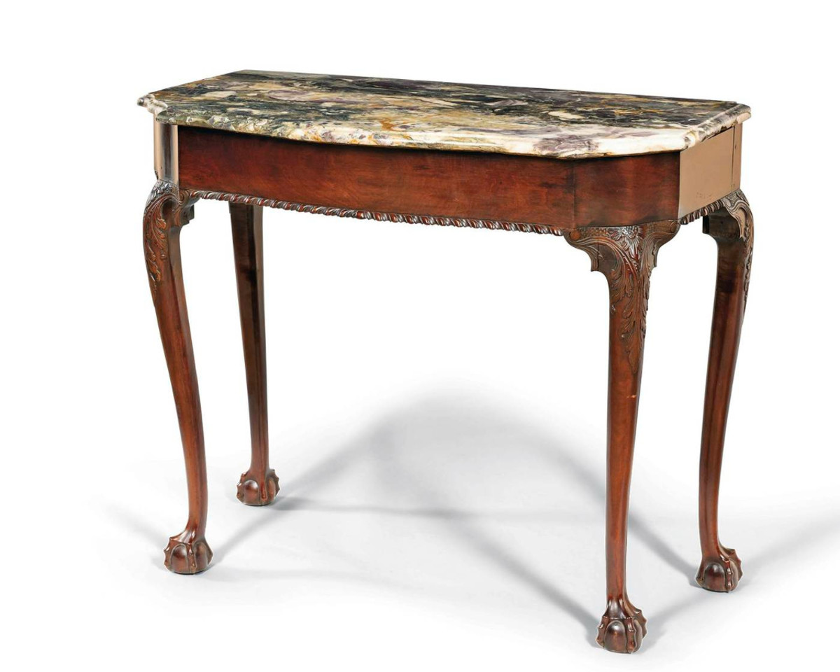 Important Chippendale carved mahogany marble-top slab table, with carving attributed to Nicholas Bernard and Martin Jugiez, Philadelphia, c. 1765. The top with serpentine front edge and serpentine corners above a conformingly shaped skirt with applied carved gadrooning below, joining four punchwork-decorated and acanthus-carved cabriole legs with carved returns continuing to claw-and-ball feet. Estimate: $100,000-$150,000.