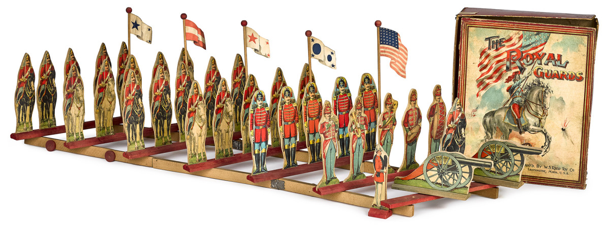 Reed lithographed paper on wood "The Royal Guards" soldier set pull toy, mounted and marching form soldiers, and two cannons which fit into a wood wheeled scissor platform base, 13" x 11", from the collection of Diane and Steve Olin. Estimate: $800-$1,200.