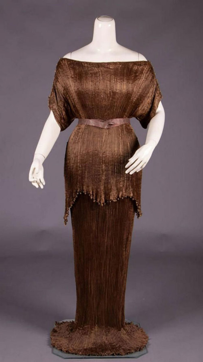 Polished to a burnished glow, this Peplos gown by Italian designer Mariano Fortuny, 1920-1930s, has all the columnar elegance of a bronze statue. Fortuny is known for his elegantly pleated silks and this bronze beauty has the extra bonus of being trimmed with Murano glass beads. Estimate: $4,000-$6.000.