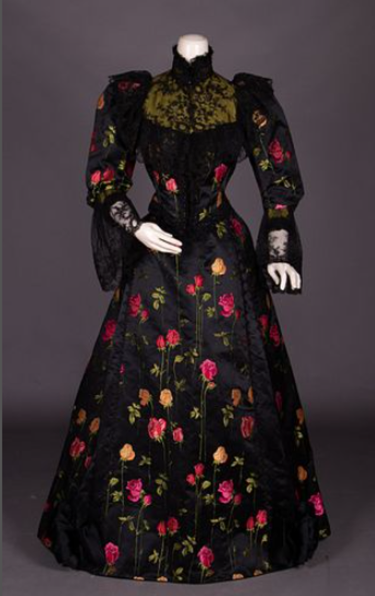 We love how the vibrant brocaded roses really pop on the black silk satin of this dinner dress, circa 1892. We also love the chartreuse silk satin yoke with filigree embroidery and the trimming of black jet. Estimate: $500-$800.