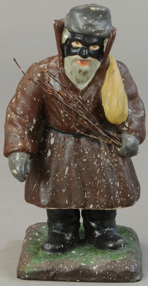 This mean-looking Belsnickle is wearing a black mask and carrying a sack of toys for good children and holding a switch to punish bad ones; 9-1/2” h. This sold for $600 in December.