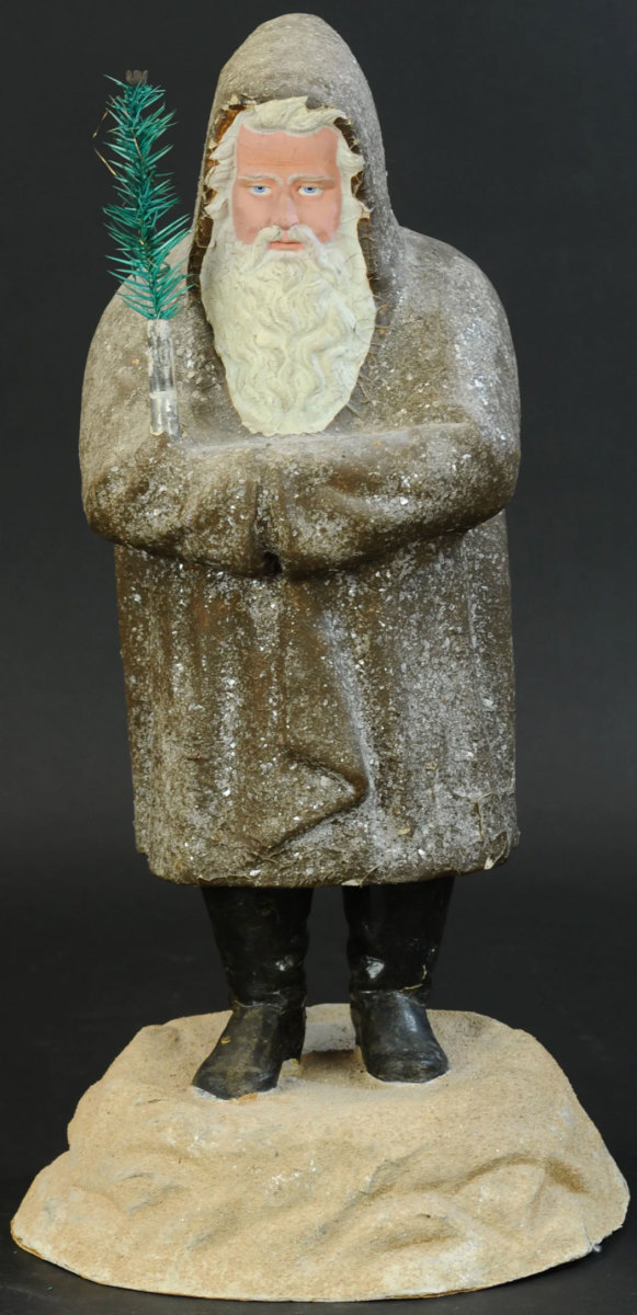 A rare and one-of-a-kind German Belsnickle with lamp fixture, circa 1870. It is standing on a snow mound, wearing a mica snow-flecked robe and has a kind but somewhat stern-looking face with blue eyes; 23" h. This sold in November for $25,000.