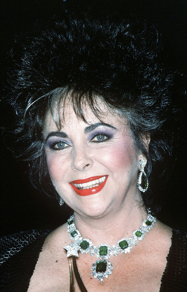 Taylor wearing her emerald and diamond necklace, brooch and earrings, circa 1986.