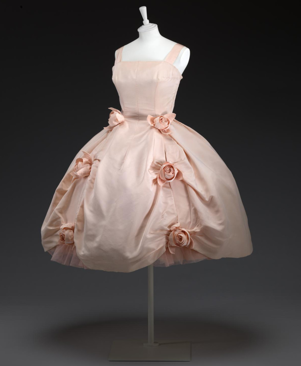 This silk and cotton Porcelaine evening dress adored with roses was designed by Yves Saint Laurent for Christian Dior’s Trapèze line, spring-summer 1958.