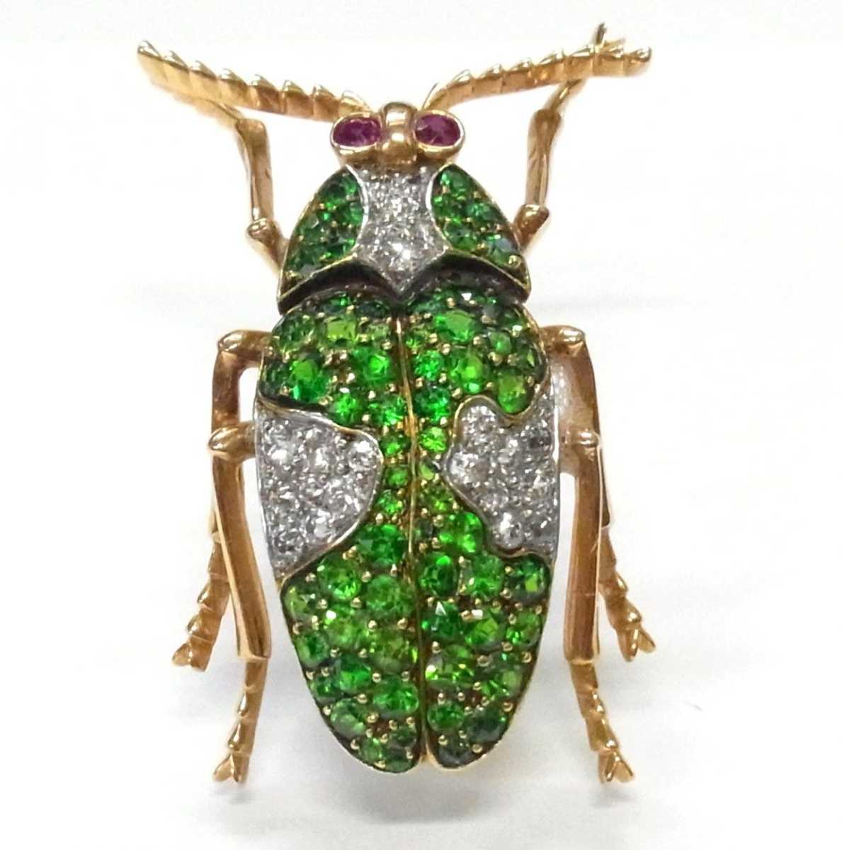 An 18k rose gold beetle brooch, encrusted with ultra-fine green demantiod garnets and old cut diamonds, and two ruby eyes, 1-3/8" x 7/8"; estimate: $3,000-$5,000.