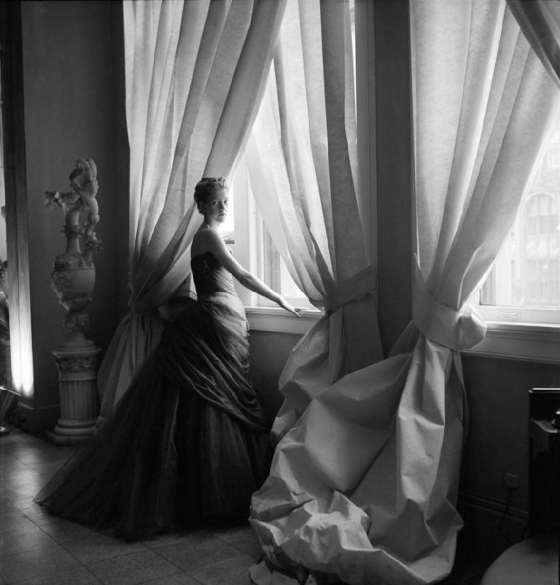 The Swan ball gown immortalized in this Cecil Beaton photograph of Charles James’ wife, Nancy James, posing by light-filled Pellon-covered windows in the James’ showroom.