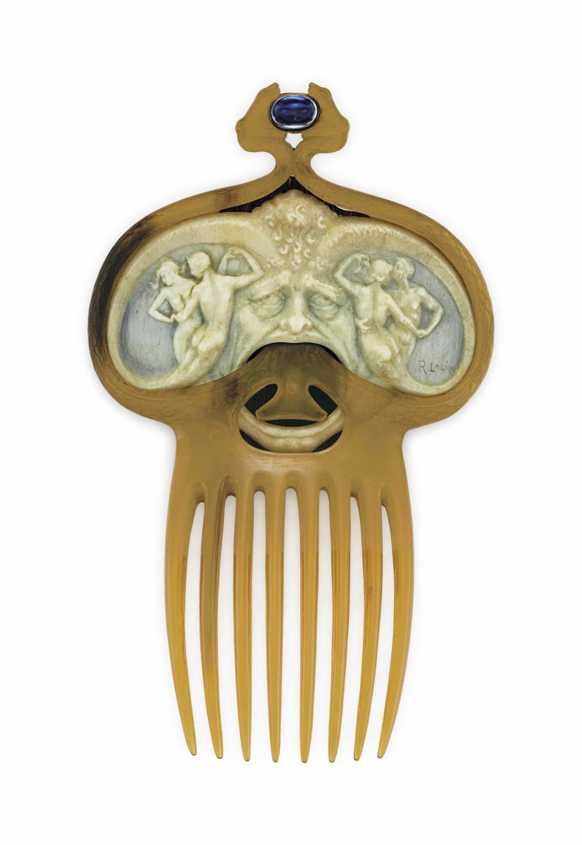 Masque with Pairs of Dancing Nymphs and Serpents: This carved galalith comb, circa 1900, depicts a pair of nymphs dancing around an open-mouthed mask within a carved horn surround designed as two serpents. It is enhanced by an oval cabochon sapphire between their mouths; 5-1/8" x 6-1/2". From the collection of Peggy and David Rockefeller, it sold in 2018 at Christie’s for $65,000.